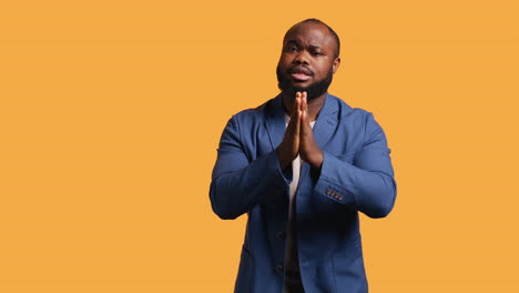 man putting hands together in apology gesture, asking for forgiveness