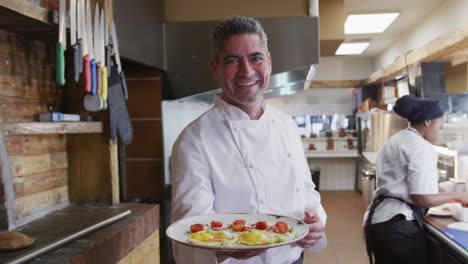 caucasian chef showing his dish