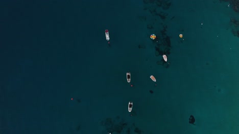 Toma-Giratoria-Aérea-Mirando-Hacia-Abajo-En-Los-Barcos-De-Recreo-Anclados-En-La-Bahía-De-Konnos