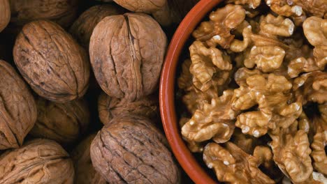 pile of walnuts and peeled nuts in bowl. view from above.