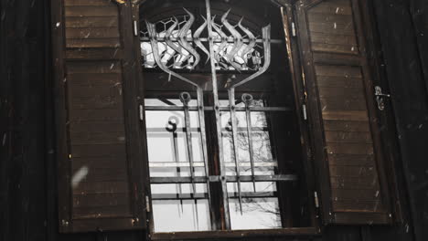 dramatic snow fall outside ironic iron windows of john bapist church in cesky jiretin