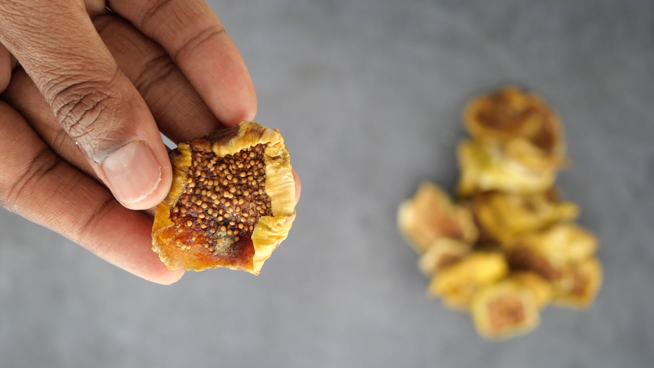 Close Up of Hand Holding a Dried Fig Showing Seeds