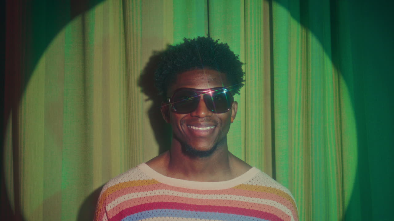 Portrait of Smiling African American Man in Retro Sunglasses in Spotlight