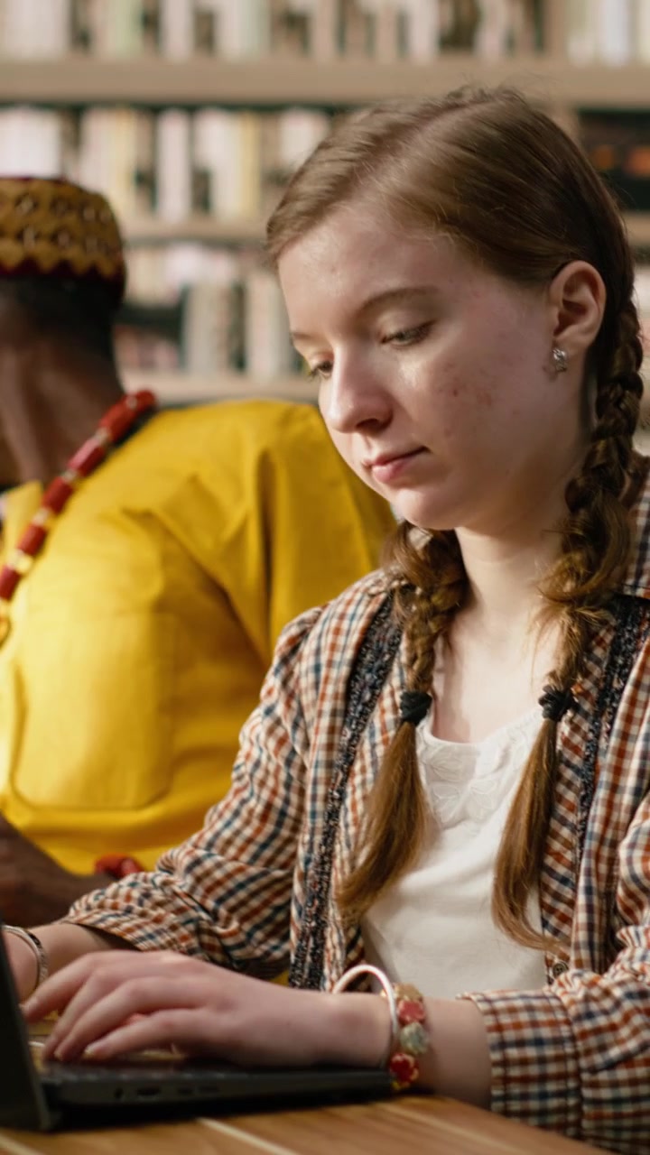 Vertical Video Woman Student Typing On Laptop And Studying At Wooden Library Table