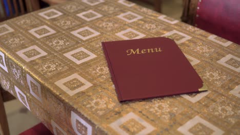 luxurious vintage style table with menu red and golden color placed on top ready for customer creative close up smooth slow motion