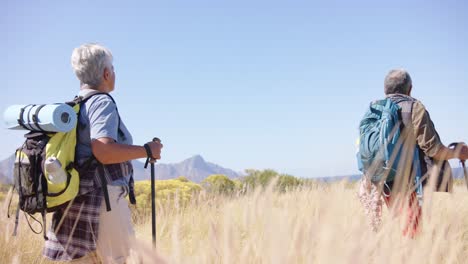 una feliz pareja biracial en las montañas haciendo senderismo, en cámara lenta