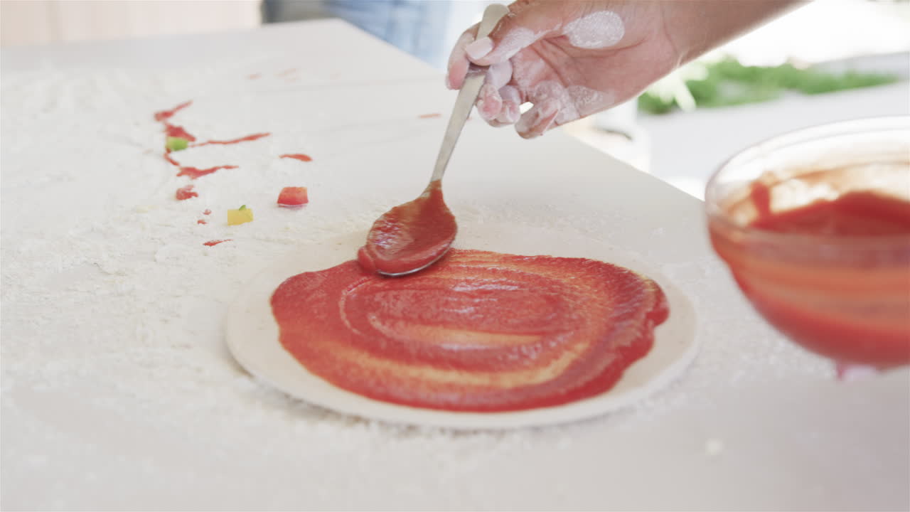 손으로 토마토 소스와 함께 피자 반죽을 집에서 준비합니다. 복사 공간이 있습니다.