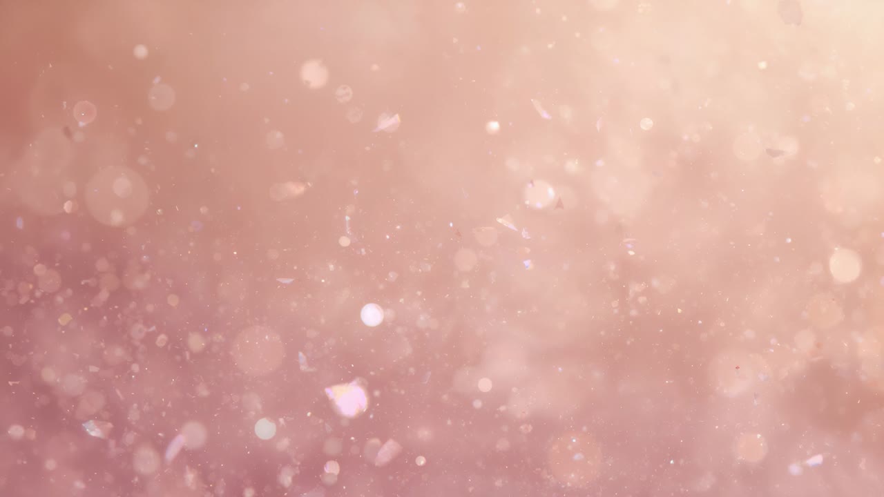 Riproduzione in avvio con granelli di polvere e luci bokeh che fluttuano su uno sfondo rosa tenue, con effetto pulsante
