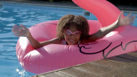 chica divirtiéndose con inflables en la piscina al aire libre