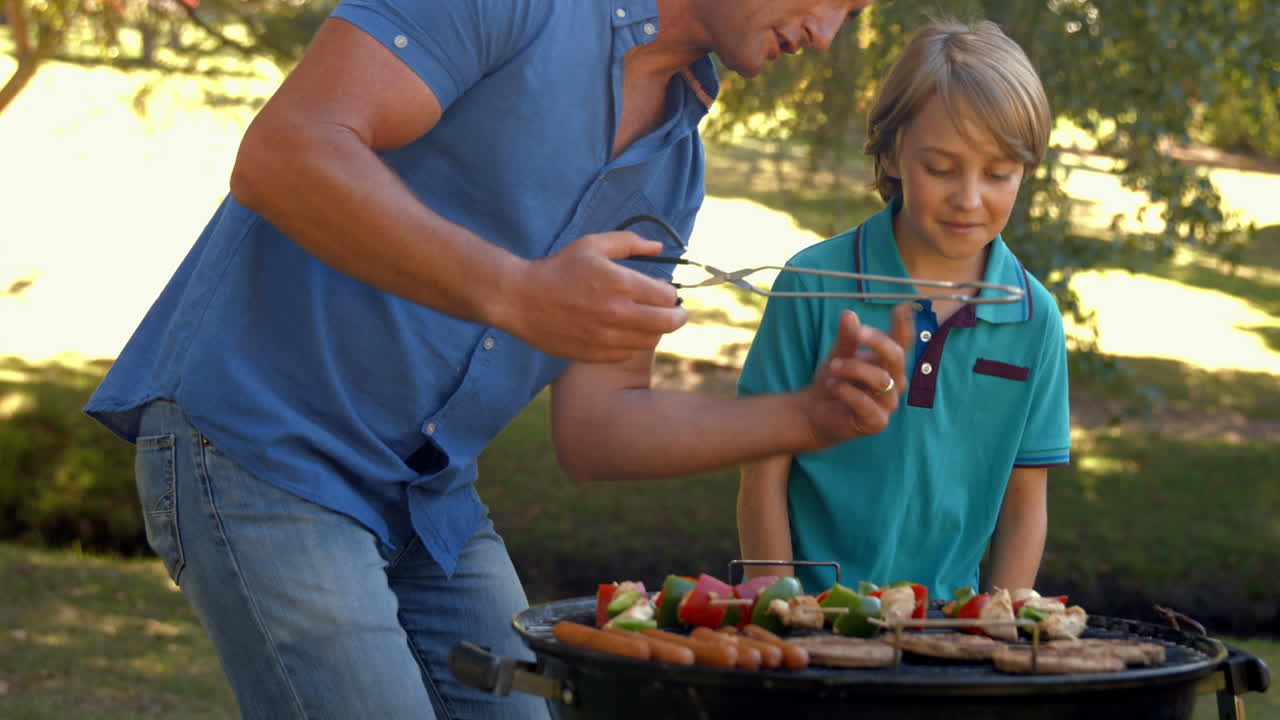 Happy father doing barbecue with his son
