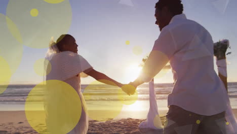 animación de puntos de luz sobre una pareja afroamericana casándose en la playa