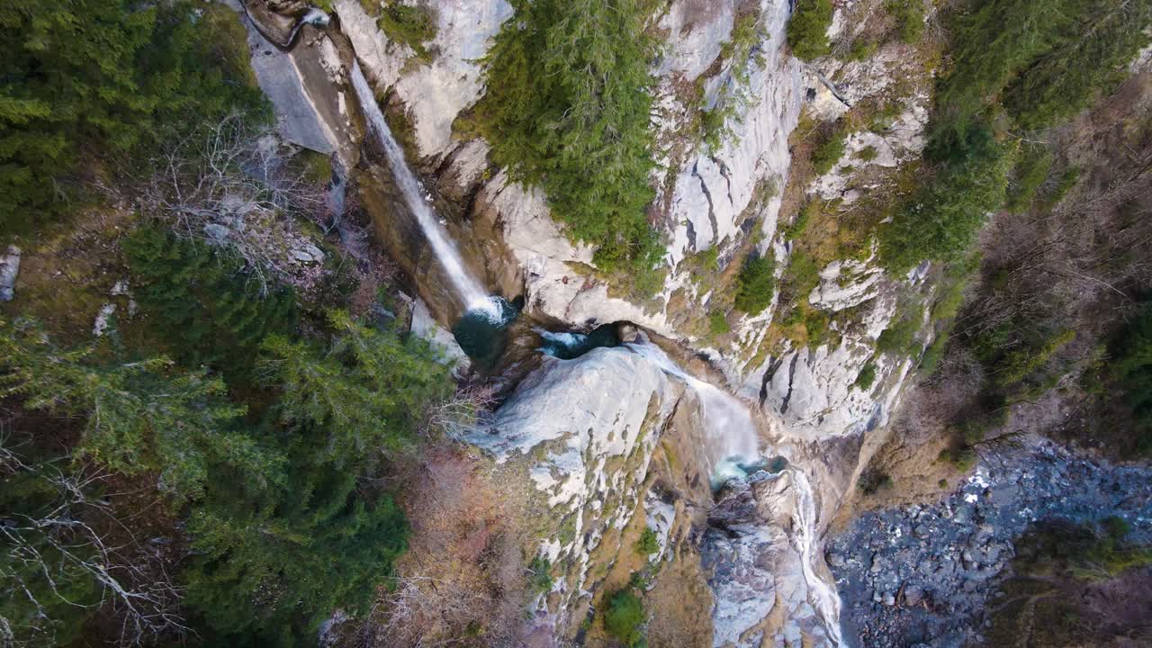 giro aéreo en cámara lenta vertical hasta una cascada en los alpes, suiza