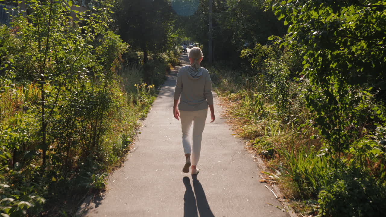 mujer caminando por un camino soleado