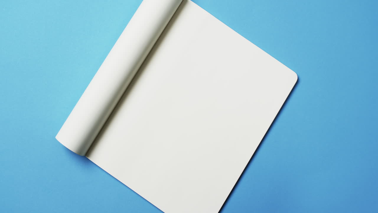 Video of book with white blank pages and copy space on blue background