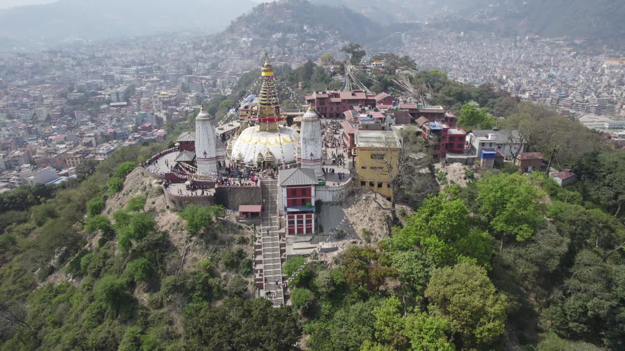 A breathtaking drone view of Swayambhunath Stupa overlooking Kathmandu City, capturing its sacred presence, hilltop beauty, and the vibrant urban sprawl surrounding this iconic heritage site