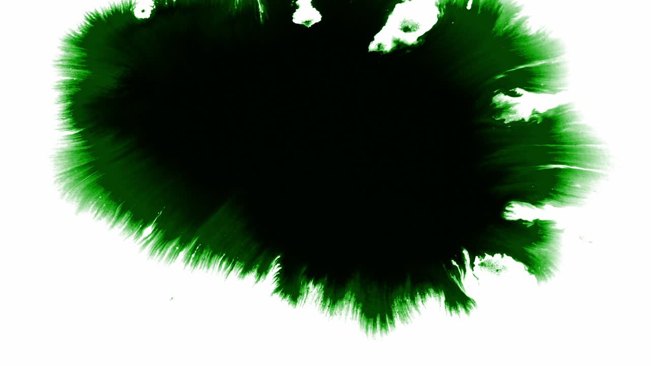 Splashes and spots of green ink spreading on white background