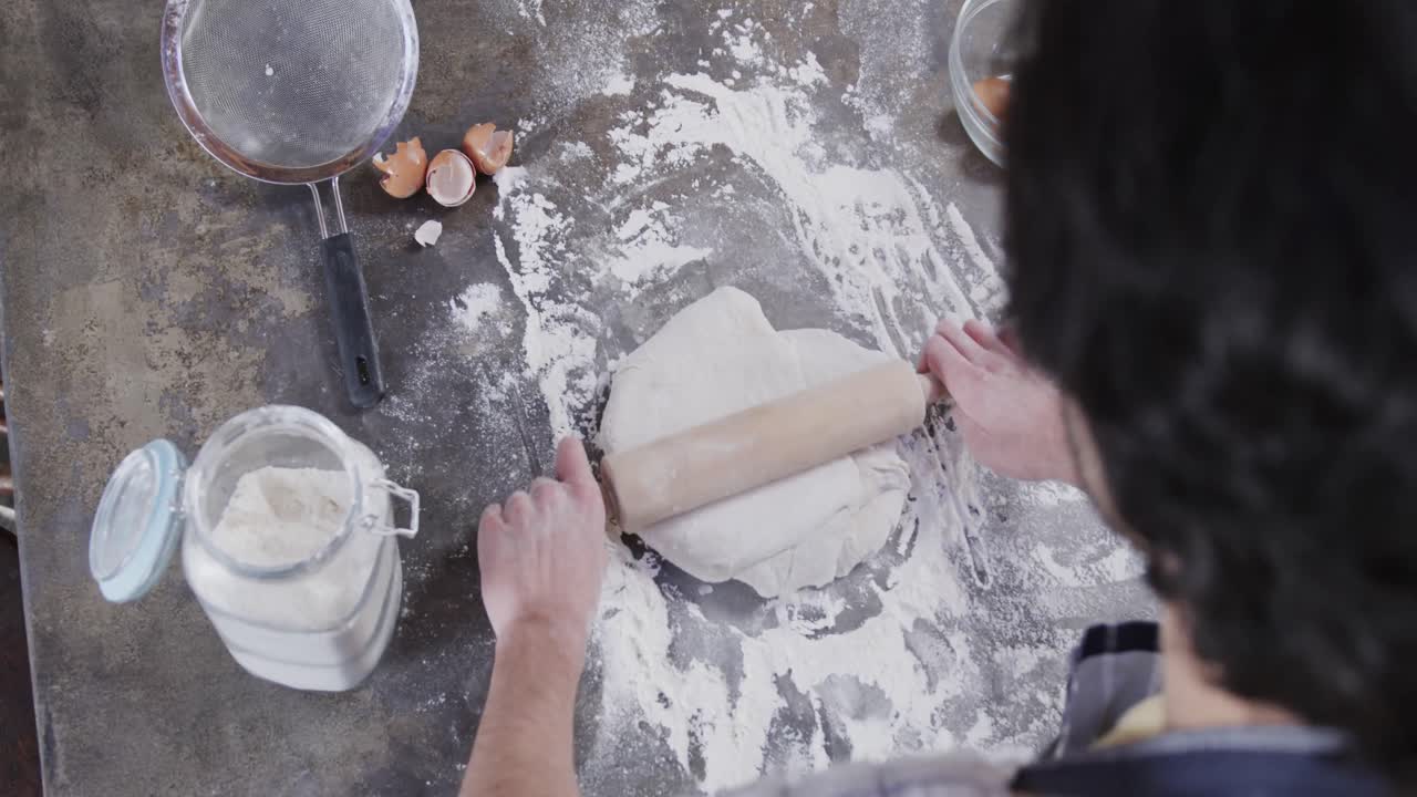 Caucasian man preparing bread dough in kitchen, slow motion
