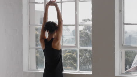 mujer de yoga saludable estirándose preparándose para el entrenamiento matutino mirando por la ventana disfrutando de un estilo de vida saludable listo para entrenar en el gimnasio