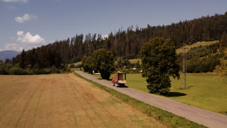 Tiny-house-transported-on-back-of-truck-in-countryside