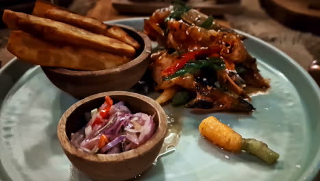 plate full of glazed fish served with thick cut fries and pickled vegetables to guests at a hotel in bali, indonesia.