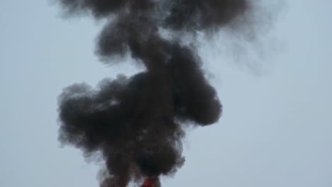 a wide shot of a large cloud of billowing black smoke