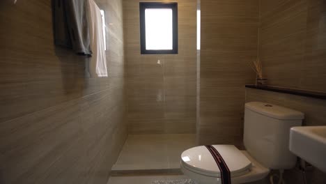 y limpio baño de baldosas de pared de color beige, a través del paseo