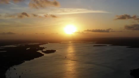 impresionante toma aérea de drones de una puesta de sol dorada que se refleja en un río amazónico gigante en la ciudad tropical de playa de tibau do sol cerca de pipa en el norte de brasil en una cálida tarde de verano
