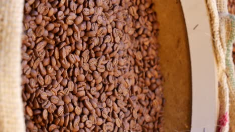 close up of a burlap sack filled with roasted coffee beans