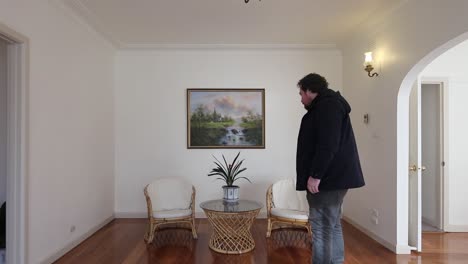 joven caminando por la pequeña sala de estar