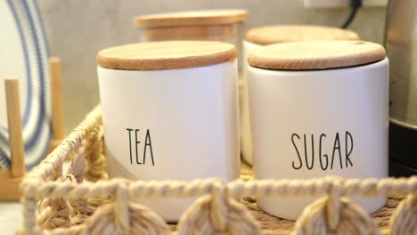 white ceramic canisters with wooden lids for tea and sugar