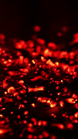 pile of glowing charcoal after the campfire burnt out. red pieces of burned wood still hot. close up. vertical video