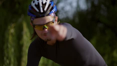 Portrait-of-a-cyclist-on-a-bike-and-showing-bang-sign-with-hand