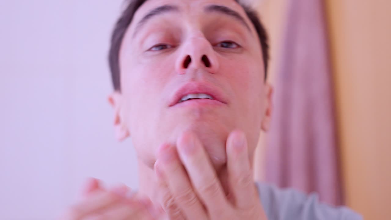 Man applying cream on his face and cocoa on lips