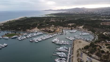 wide rotating drone footage of the marina near san jose del cabo in los cabos mexico with boats docked in harbor