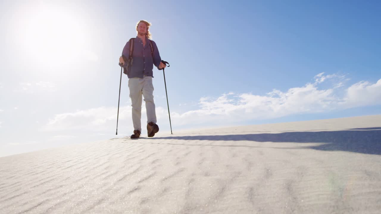 hombre con caña de senderismo caminando en el desierto 4k