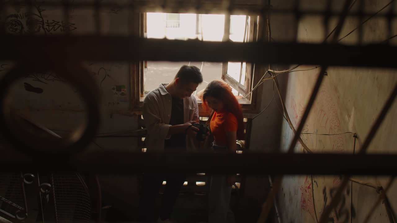 Man Photographing Model near Window inside Abandoned Building
