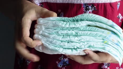 stack of baby diapers held in hands