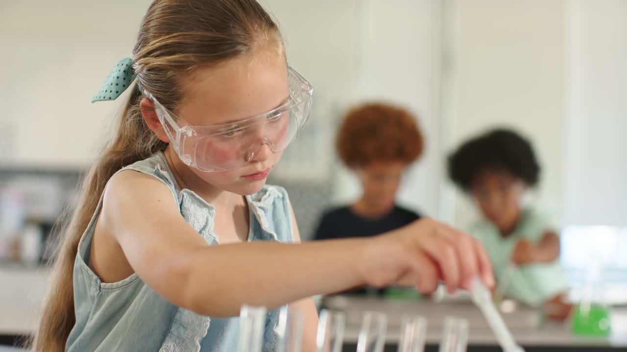 Compagni di classe che osservano la telecamera in movimento, una ragazza adolescente che pipetta un liquido verde in provette per il laboratorio scolastico.