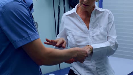 joven médico asiático examinando a un paciente anciano en la clínica 4k