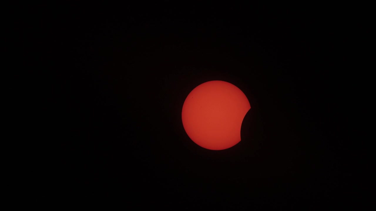 Cinematic close-up shot of the sun captured in the initial full eclipse phase, revealing sharp, dramatic contrast and rich orange hues against a pitch-black sky, perfect for astronomy projects.