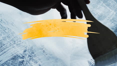 animation of yellow paint smudge with copy space over hand with paint brushing background