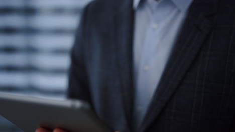 Tablet-computer-in-business-man-hands-closeup.-Professional-scrolling-tablet