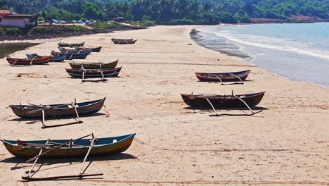 aerial view over traditional dhoni fishing vessels, moored on a beach in india