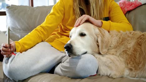 Woman-taking-selfie-with-her-dog-on-sofa-4k