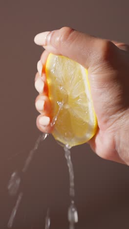 Female-squeezing-juice-out-of-half-a-lemon-in-slow-motion