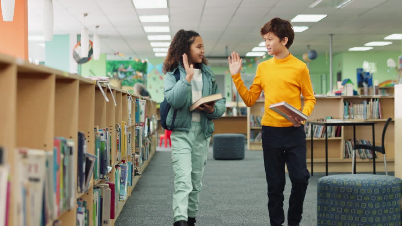 Two children high five each other in the library