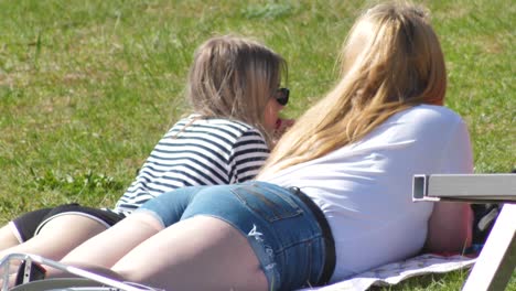 Two-girls-sunbathing-on-the-beach-in-the-grass-hall