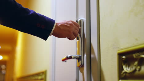 unrecognizible man arrived to hotel and opens the room with electronic key. selective focus on a door handle.