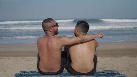 gay couple relaxing on beach