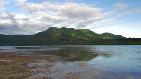 vista junto al agua de las verdes colinas boscosas